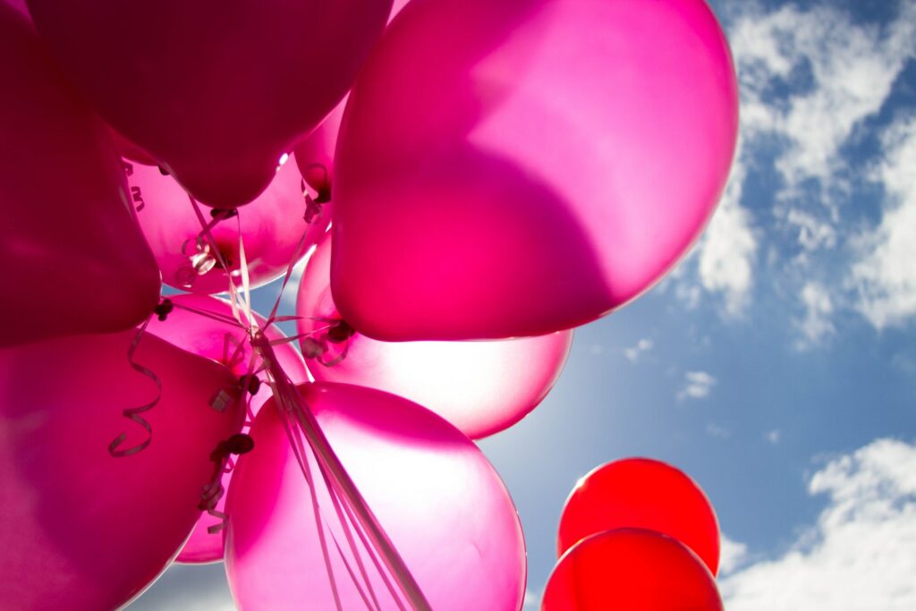 Rosa und rote Luftballons am Tag