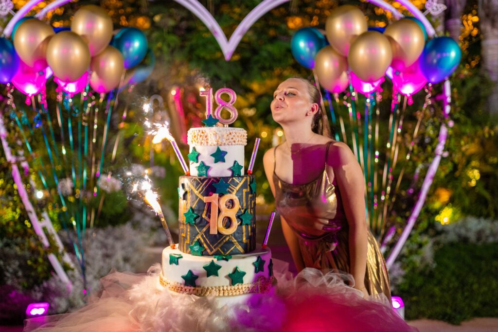 Mulher aniversariante soprando velas em bolo durante a celebração