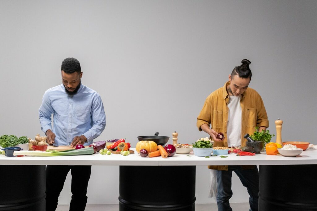 Homens fatiando vegetais frescos em uma mesa