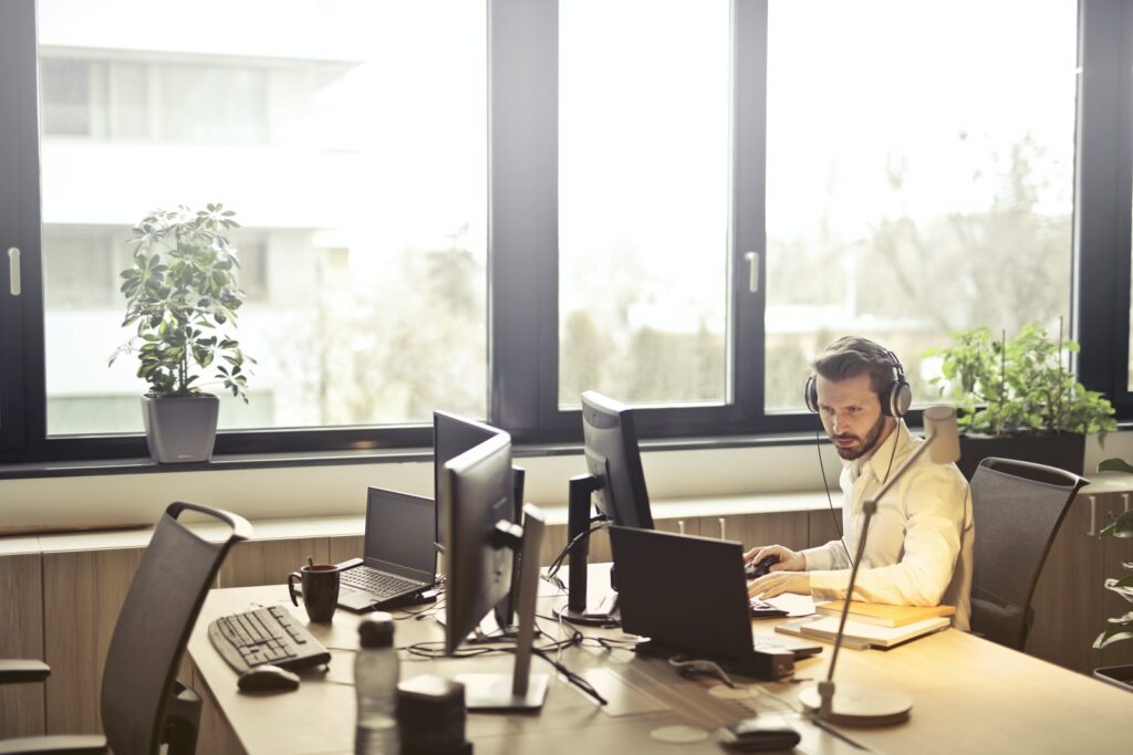 Hombre con auriculares frente al monitor del ordenador