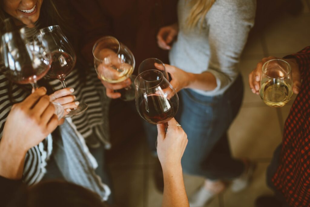 Gruppe von Menschen wirft Weinglas