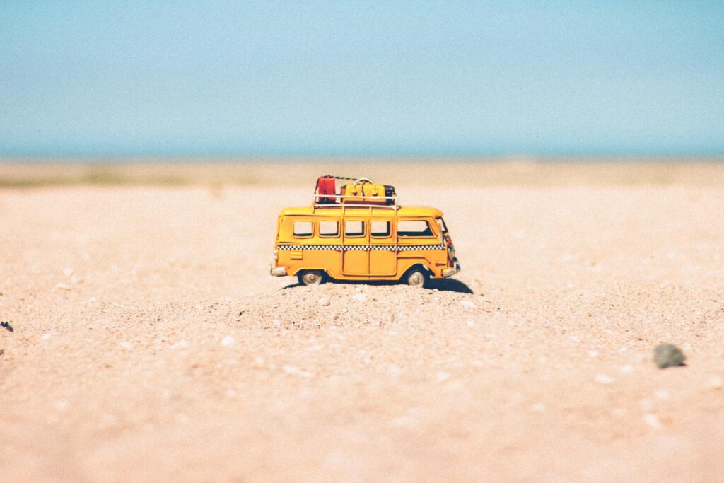 茶色の砂の上に黄色のダイキャスト製ミニチュア・バン