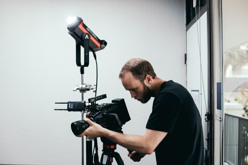 Man in Black Crew Neck T-shirt Holding Black and Red Camera