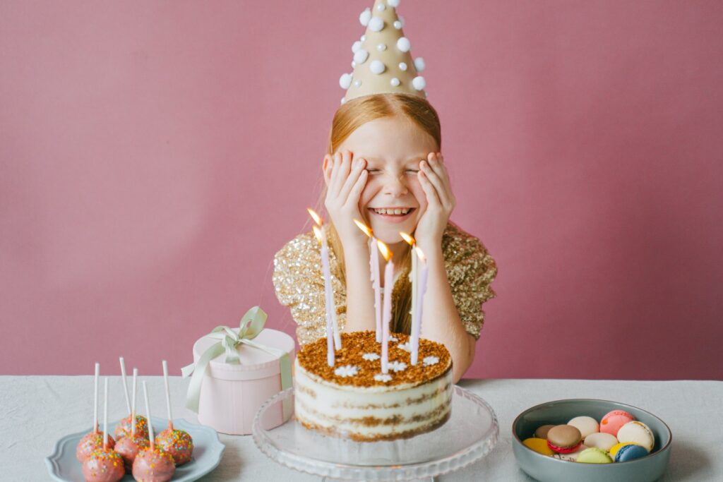 Chica feliz con vestido dorado celebrando su cumpleaños