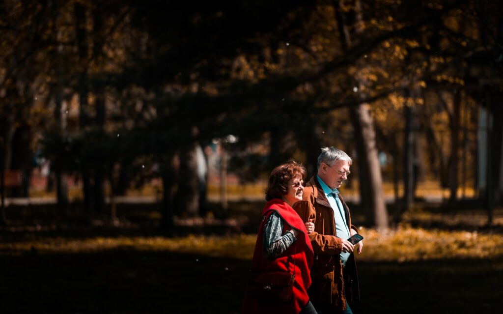 uomo e donna che camminano accanto agli alberi
