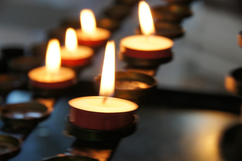 зажженные свечи на черном металлическом подсвечнике