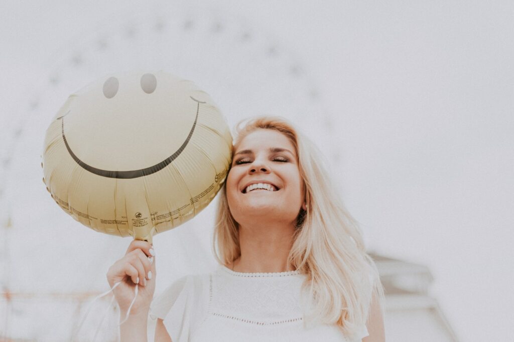 Mujer sosteniendo un globo sonriente