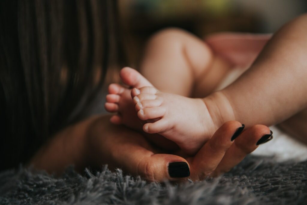 選択焦点写真で赤ちゃんの足を持つ人