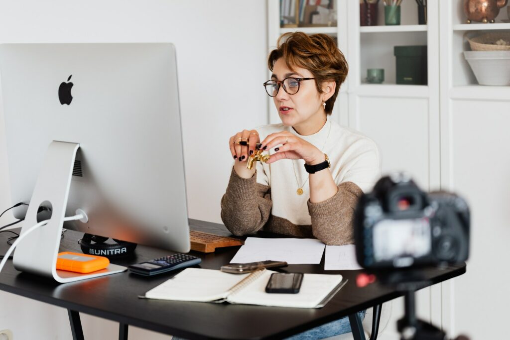 Donna elegante e sicura di sé con occhiali da vista che ospita un webinar