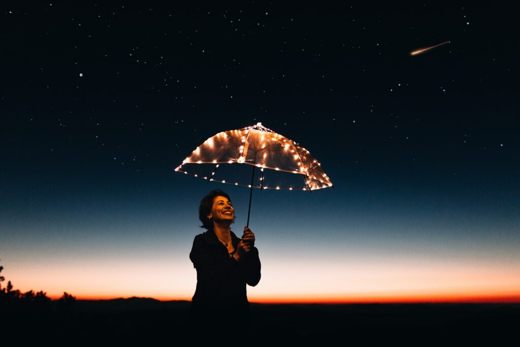 Frau mit Regenschirm und Lichtern