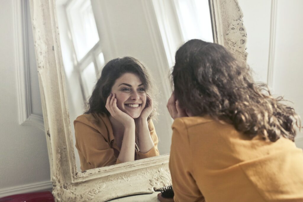 Foto di donna che si guarda allo specchio