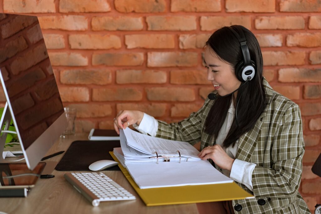 A mulher em Blazer Plaid Blazer Comunicando enquanto olha para os arquivos