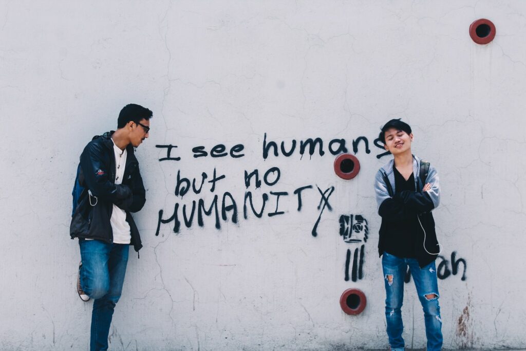 Dos hombres de pie junto a una pared pintada